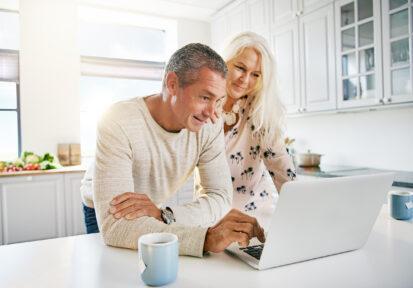 Couple looking at computer in their kitchen